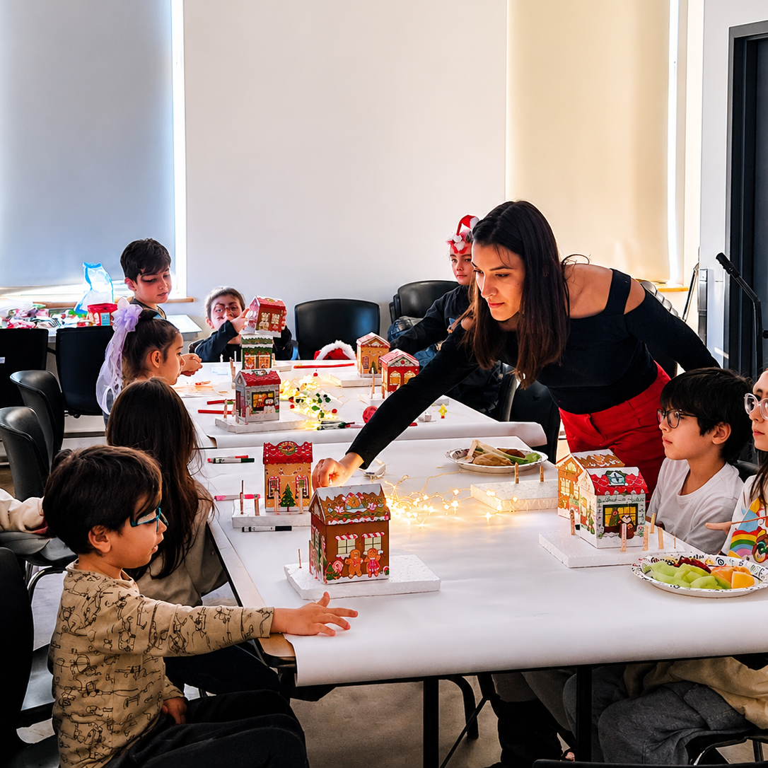 Begüm helping children build architectural models in the studio